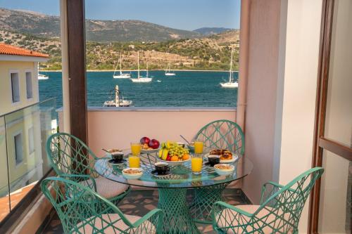a table with food on a balcony with a view of the water at Pink Panther Maisonette Suite in Argostoli