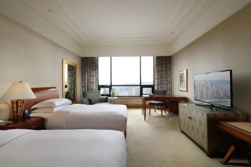 a hotel room with two beds and a large window at Hilton Chongqing in Chongqing