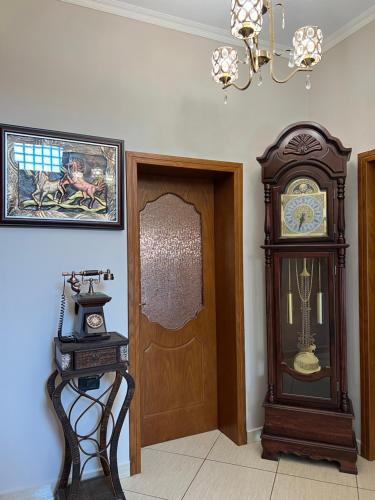 a room with a grandfather clock next to a door at Guest House Pulake in Berat