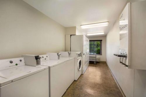 a white laundry room with a washer and dryer at WoodSpring Suites Louisville Southeast in Louisville