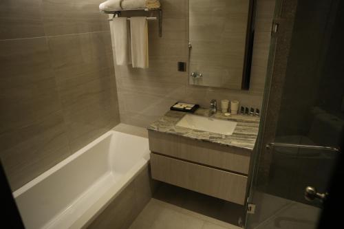 a bathroom with a bath tub and a sink at Lakeshore Heights in Dhaka