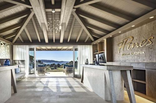 eine Lobby mit einer Bar mit Aussicht in der Unterkunft 7Pines Resort Sardinia - A Destination By Hyatt in Baja Sardinia