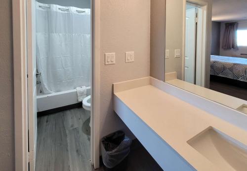 a bathroom with a sink and a toilet and a mirror at Motel 6 Wichita KS South I35 in Wichita