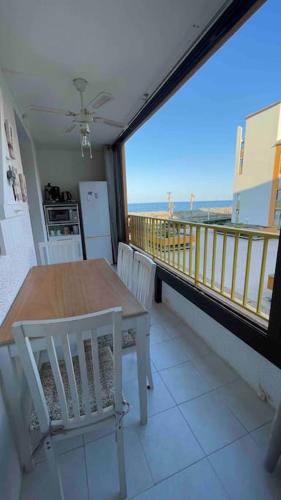 une table et des chaises sur un balcon avec vue sur l'océan dans l'établissement Appart T2 / 4 personnes - Les pieds dans l’eau, au Barcarès