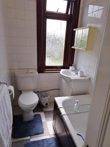 a bathroom with a toilet and a sink and a window at Double Room available- London Seven Kings Seven Kings Train Station in Seven Kings