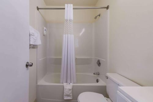 y baño blanco con ducha y aseo. en Rodeway Inn Livermore en Livermore
