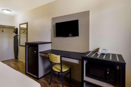 a hotel room with a desk and a television at Rodeway Inn Livermore in Livermore