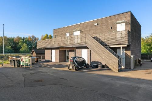 a building with a car parked in a parking lot at Experience a Cozy Getaway Near Pulpit Rock-A unit in Strand