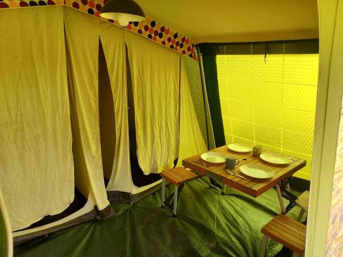 a room with a table and chairs and a window at Camp marsac in Saint-Thurial