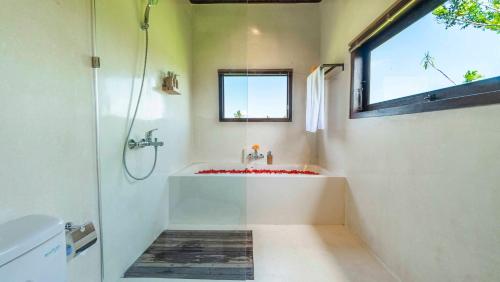 a bathroom with a tub and a sink and a window at Gayatri Retreat Ubud in Ubud