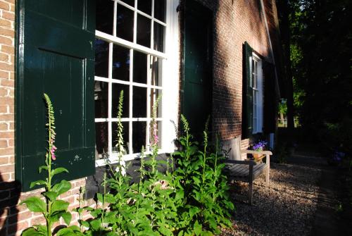 a window on the side of a building with a bench at Landgoedhoeve Vosbergen in Heerde