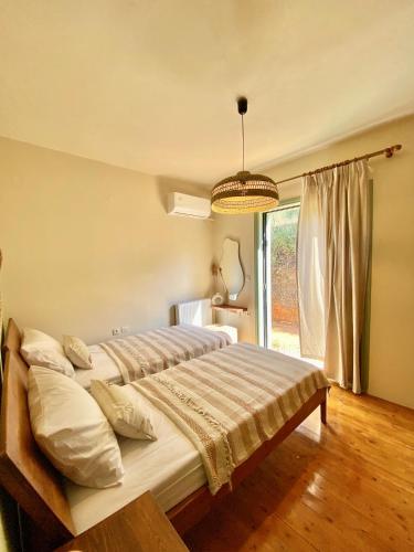 um quarto com 2 camas e uma grande janela em The Leaf House em Varípetron