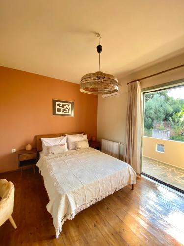 um quarto com uma cama e uma grande janela em The Leaf House em Varípetron