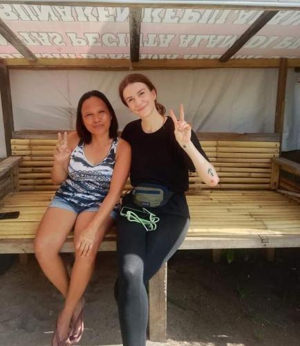 two women sitting on a bench under a tent at Naca Homestay in Manado