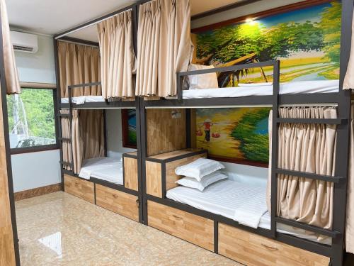 a room with three bunk beds in a house at Tam Coc Guest House & Hostel in Ninh Binh