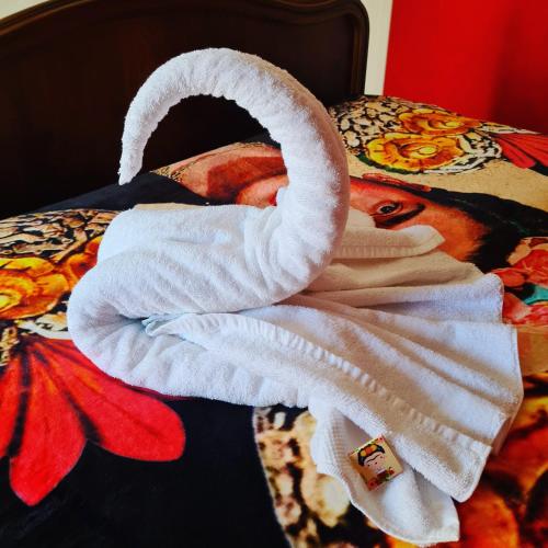 a white towel sitting on top of a bed at Frida's Cottage Whitby in Whitby