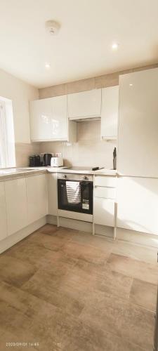 a kitchen with white cabinets and a black appliance at Woodfield apartment in The Hyde