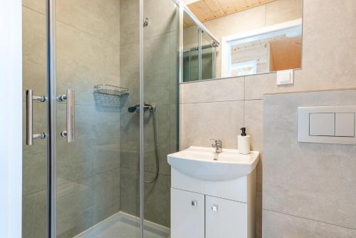 a bathroom with a shower and a sink at SIEDLISKO JANTAR Resort&Spa in Jantar