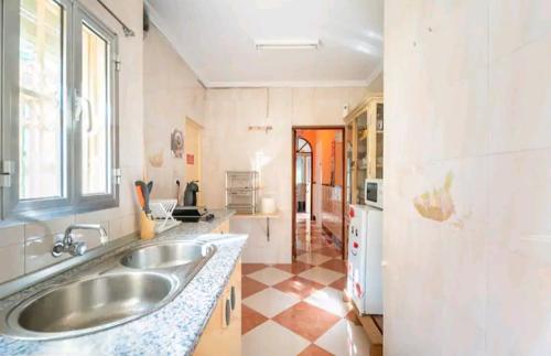 a large kitchen with a sink and a window at Ikigai House in Seville