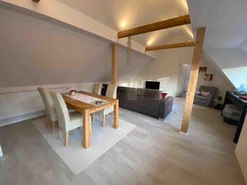 - un salon avec une table en bois et un canapé dans l'établissement Schönes Loft in Bergrheinfeld 90 qm max 5 Personen, à Bergrheinfeld
