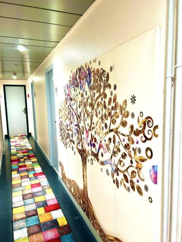 a hallway with a tree mural on the wall at Kyriad Restaurant Centre SPA Vichy in Vichy