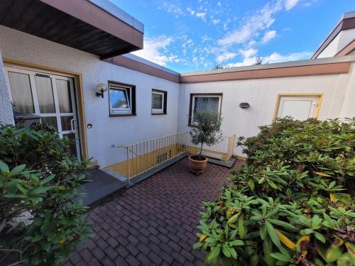 a house with a porch with a potted plant at Apartment close to nature,airport, fair in Ratingen