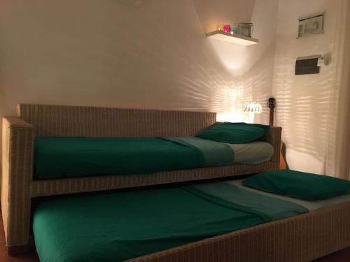 1 dormitorio con 2 camas y almohadas verdes en Porto Antigo 2 Beach Club, en Santa Maria