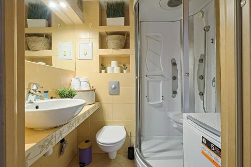 y baño con aseo, lavabo y ducha. en 2Br Apt Balcony Tamka 17 AC, en Varsovia