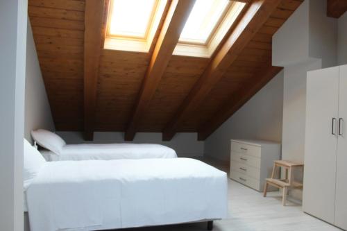 a bedroom with two beds and a wooden ceiling at Bene39 in Turin
