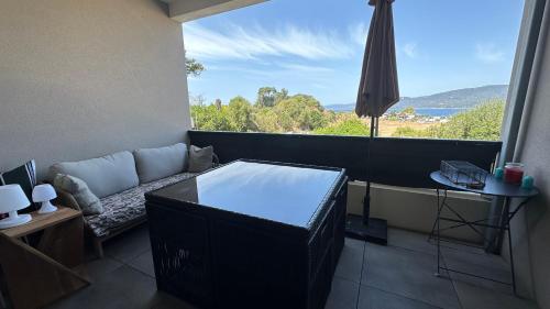 a living room with a couch and a large window at Studio T1 bis vue mer Propriano in Propriano