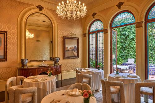 un comedor con mesas y sillas y una lámpara de araña en Palacio Ca Sa Galesa, en Palma de Mallorca