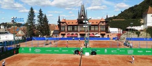 un court de tennis avec un grand bâtiment en arrière-plan dans l'établissement Old Town Cozy Flat, à Braşov