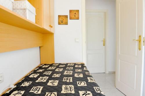 a bedroom with a bed with black and white comforter at Sea View Family Villa with Private Pool, San Juan de los Terreros in Pulpí
