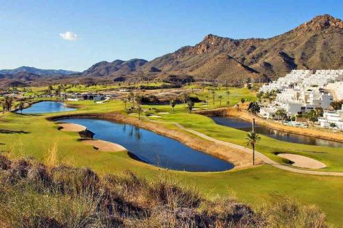 a view of a golf course with mountains in the background at Sea View Family Villa with Private Pool, San Juan de los Terreros in Pulpí