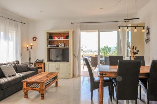 a living room with a table and a couch at Sea View Family Villa with Private Pool, San Juan de los Terreros in Pulpí