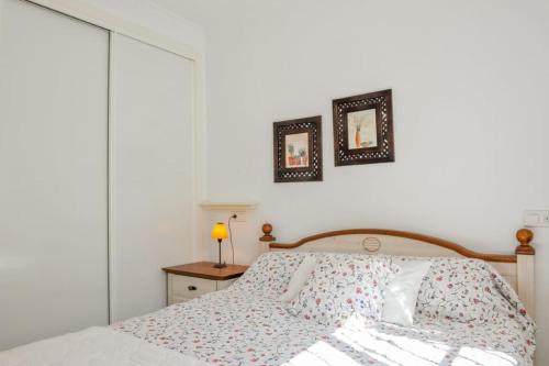 a bedroom with a bed and two pictures on the wall at Sea View Family Villa with Private Pool, San Juan de los Terreros in Pulpí