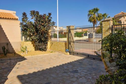 a metal fence with a gate in a yard at Sea View Family Villa with Private Pool, San Juan de los Terreros in Pulpí
