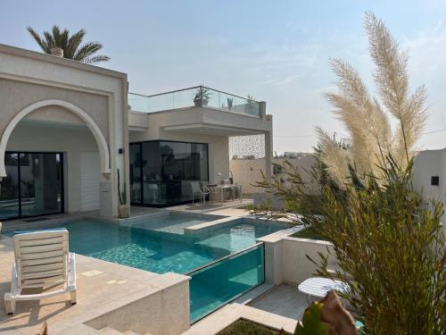 uma villa com uma piscina e uma casa em Villa Dar lynoute em Taguermess