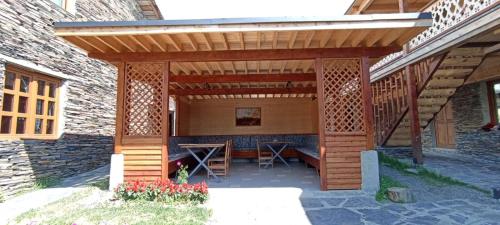 an outdoor patio with a wooden pergola at Guest House Shina in Omalo