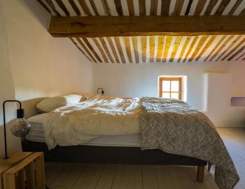 een bed in een kamer met een houten plafond bij Secluded house with amazing view and swimming pool in Buis-les-Baronnies