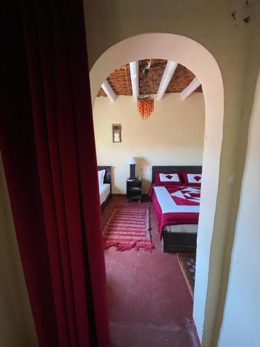 a bedroom with a bed and an arched doorway at Tizi Maison d'Hôtes in Telouet
