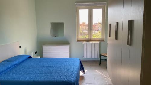 a bedroom with a blue bed and a window at I due ulivi in Arzano