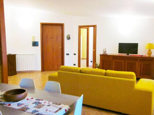 a living room with a yellow couch and a table at I due ulivi in Arzano