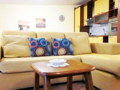 a couch with pillows and a table in a living room at I due ulivi in Arzano