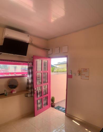 Cette chambre dispose d'une porte rose et d'une fenêtre. dans l'établissement Et Malio Stay & Travel, à Sentool