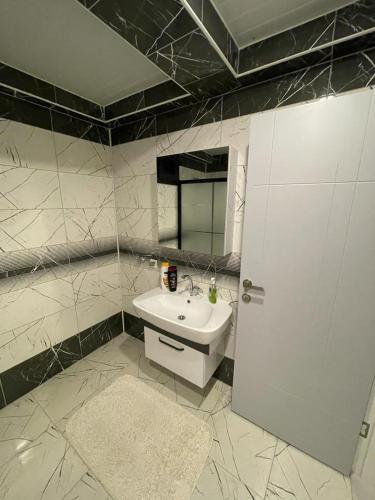 een badkamer met een witte wastafel en een spiegel bij Sırel Plaza in Nigde
