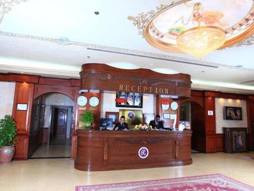 a reception desk in a hotel lobby with two people at RAMEE SUITE 3 in Manama