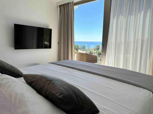 a bedroom with a large bed with a large window at Moonlight B&B Spa Wellness in Teulada