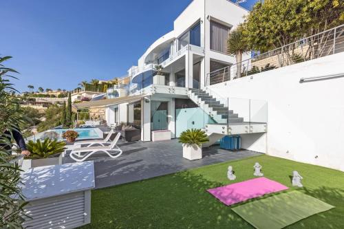 a large white house with a yard with yoga mats at Moonlit BB Spa Art boutique Cab in Teulada