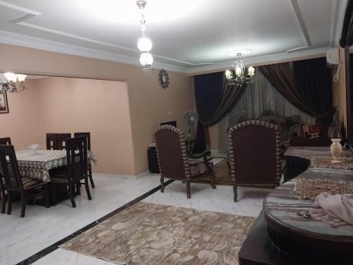 sala de estar con sillas, mesa y cama en Compound city towers en El Cairo